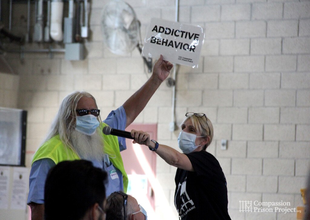 Man holding up sign that says 'addictive behavior'